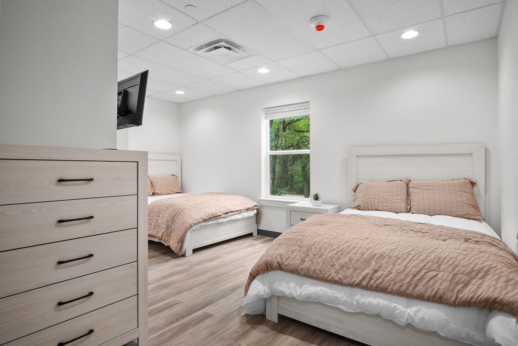 Bedroom with two beds and a dresser